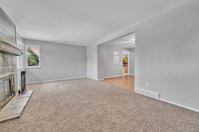 3463 W Bowles Ave, Littleton, CO 80123 - unfurnished living room with carpet flooring, a fireplace, and ceiling fan