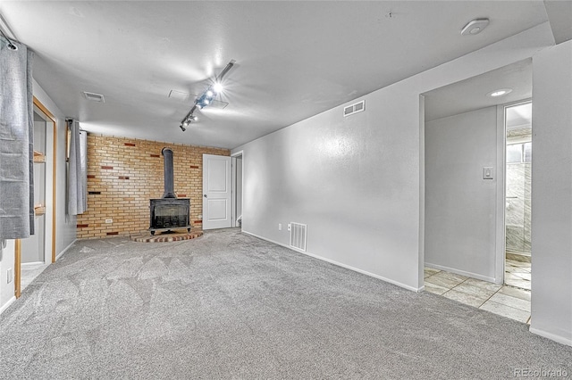 3463 W Bowles Ave, Littleton, CO 80123 - unfurnished living room featuring a wood stove, carpet flooring, and rail lighting