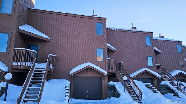 snow covered property featuring a garage