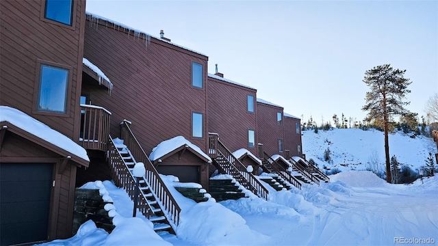 view of snow covered exterior with a garage