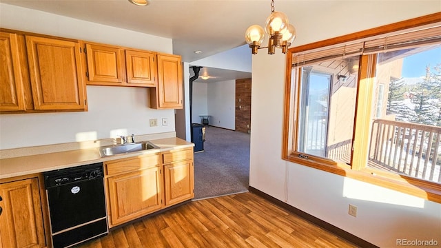 kitchen featuring dishwasher, decorative light fixtures, light hardwood / wood-style floors, sink, and a notable chandelier