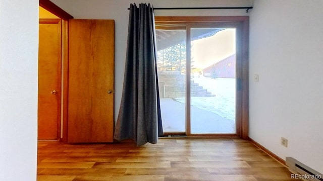 interior space with light hardwood / wood-style floors and a baseboard heating unit