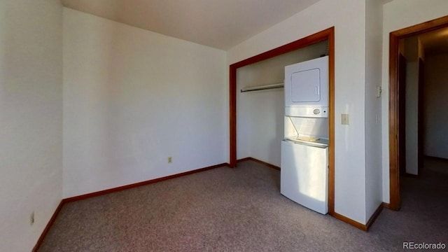 unfurnished bedroom with light colored carpet, stacked washer and clothes dryer, and a closet