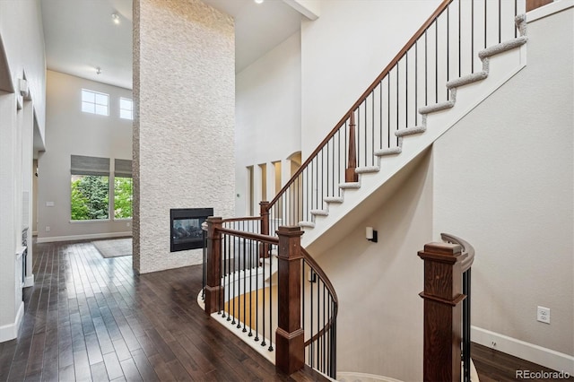 2264 S Joyce St, Lakewood, CO 80228 - staircase with a high ceiling, plenty of natural light, baseboards, a fireplace, and wood-type flooring
