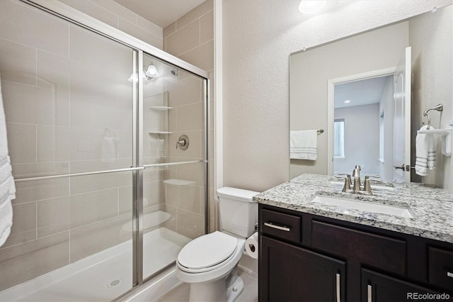 2264 S Joyce St, Lakewood, CO 80228 - bathroom featuring a stall shower, toilet, and vanity