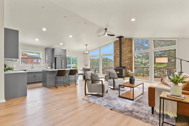 30221 Stagecoach Blvd, Evergreen, CO 80439 - living room featuring a wood stove, a ceiling fan, light wood-style flooring, vaulted ceiling, and recessed lighting