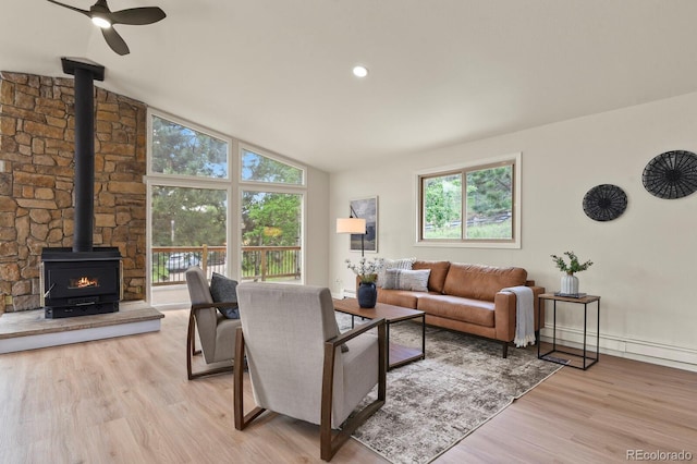 30221 Stagecoach Blvd, Evergreen, CO 80439 - living room with a wood stove, light wood finished floors, vaulted ceiling, and ceiling fan