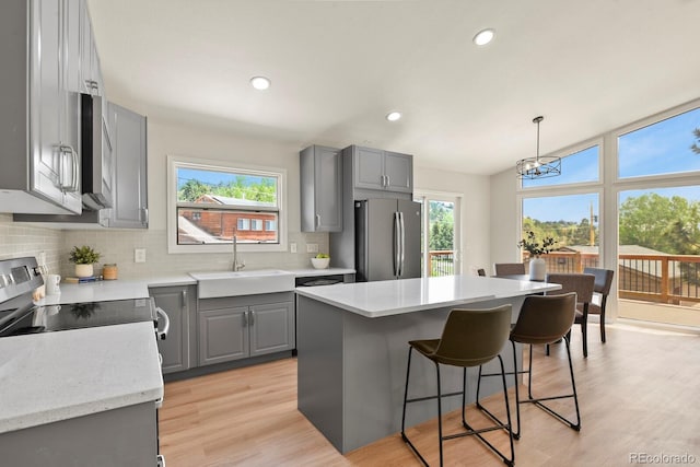 30221 Stagecoach Blvd, Evergreen, CO 80439 - kitchen with gray cabinets, stainless steel appliances, a sink, decorative backsplash, and a breakfast bar area