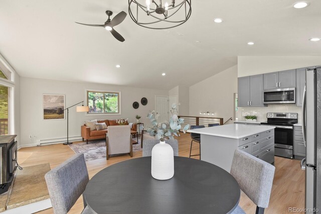 30221 Stagecoach Blvd, Evergreen, CO 80439 - dining space with a baseboard heating unit, vaulted ceiling, light wood-type flooring, ceiling fan, and a chandelier