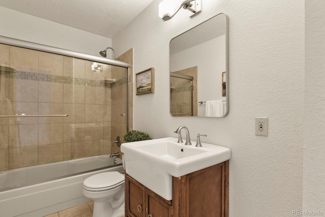 30221 Stagecoach Blvd, Evergreen, CO 80439 - bathroom with a textured wall, vanity, toilet, shower / bath combination with glass door, and tile patterned flooring