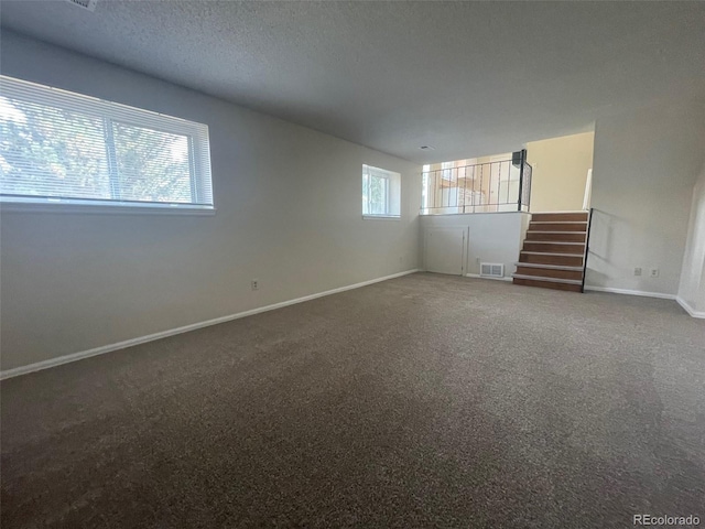 carpeted spare room featuring a textured ceiling