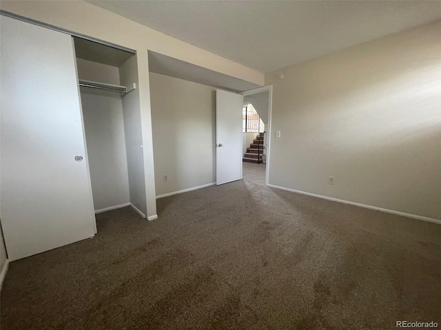 unfurnished bedroom with a closet and dark carpet