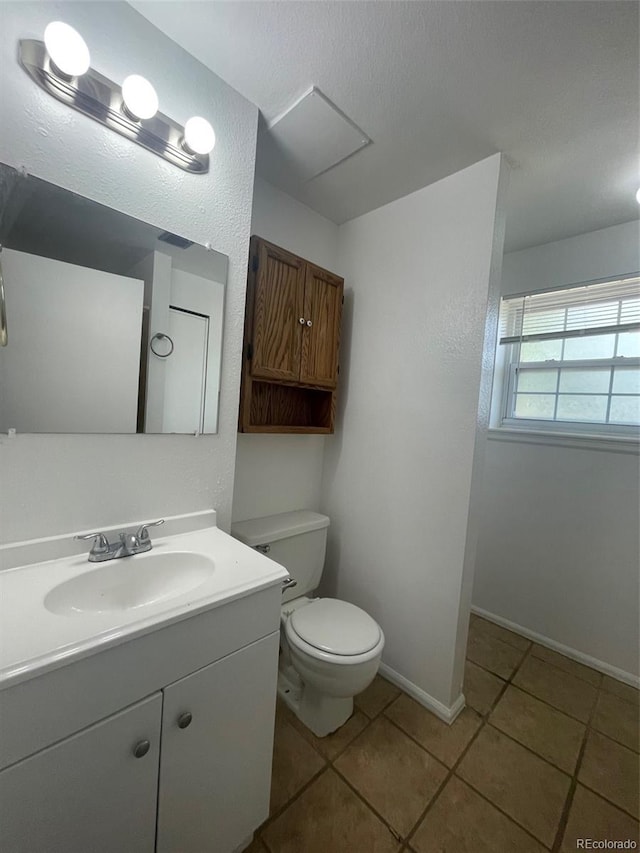 bathroom featuring toilet, oversized vanity, and tile flooring