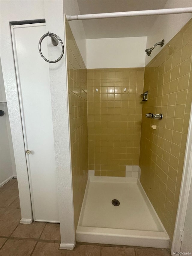 bathroom with tile flooring and a tile shower