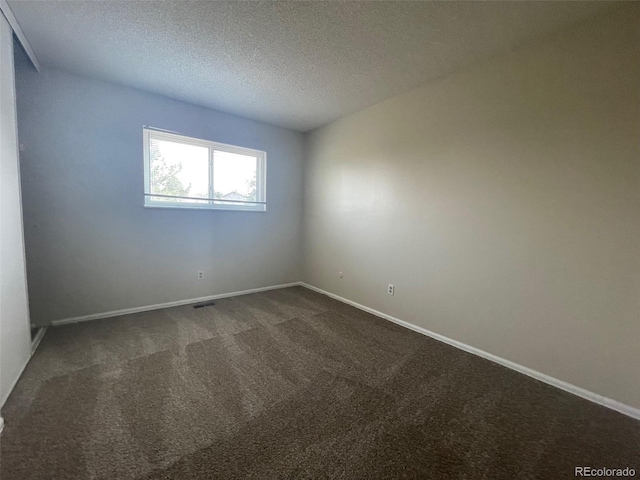 carpeted empty room with a textured ceiling