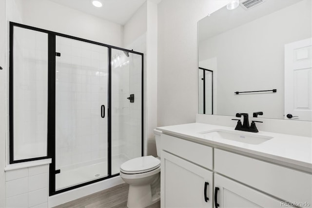 bathroom with vanity, hardwood / wood-style flooring, toilet, and an enclosed shower