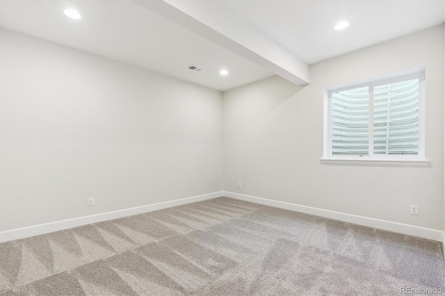 carpeted spare room with beam ceiling