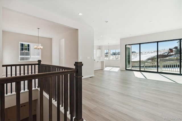 hall with a chandelier and light hardwood / wood-style floors