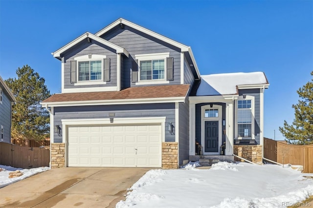 craftsman inspired home featuring a garage, driveway, stone siding, and fence