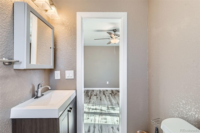 bathroom with ceiling fan, vanity, and toilet