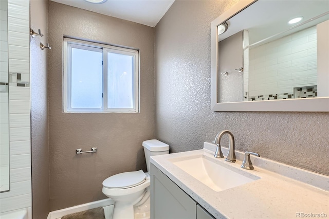 bathroom featuring vanity, toilet, and a tile shower