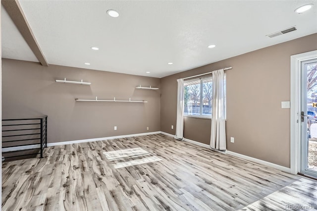 empty room with light hardwood / wood-style flooring and a healthy amount of sunlight