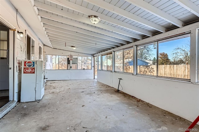 unfurnished sunroom with vaulted ceiling with beams