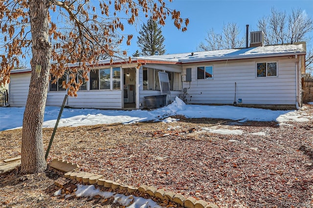 snow covered rear of property featuring cooling unit