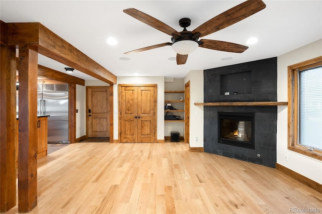 unfurnished living room with baseboards, a tile fireplace, wood finished floors, ceiling fan, and recessed lighting