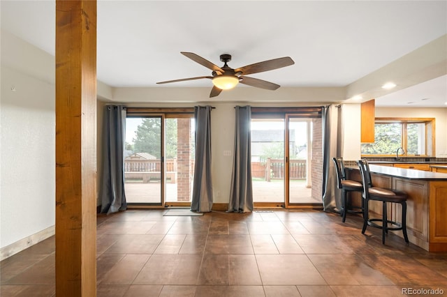 dining area featuring plenty of natural light, a ceiling fan, baseboards, recessed lighting, and dark tile patterned flooring