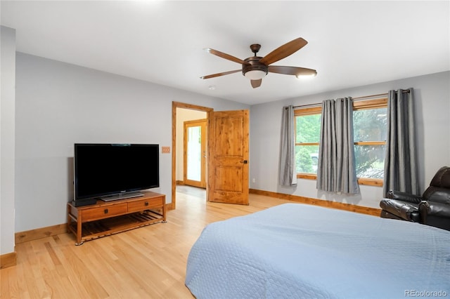 bedroom with light wood-style flooring, baseboards, and a ceiling fan