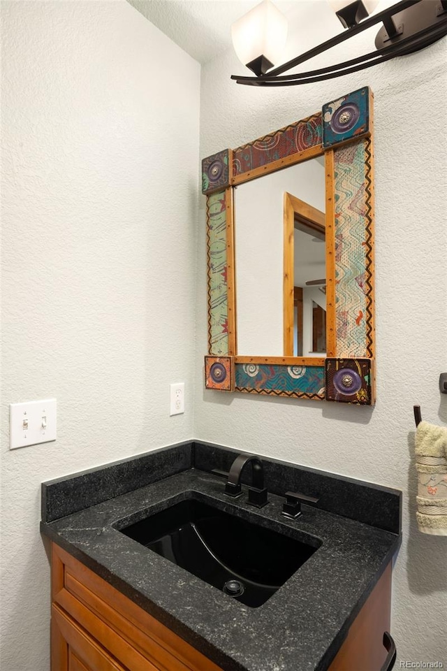 bathroom featuring a textured wall and vanity