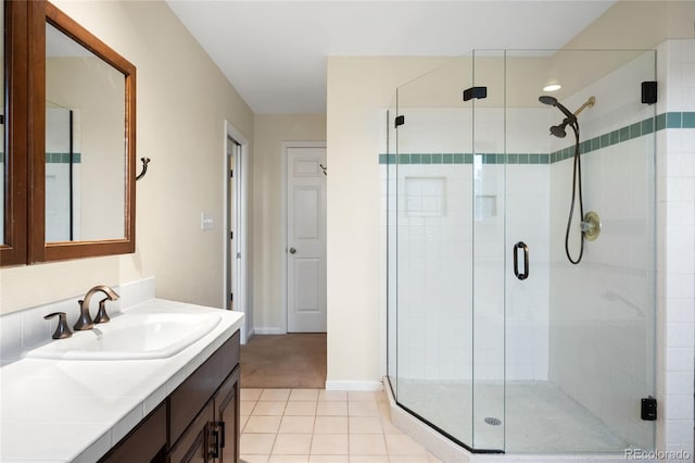 bathroom featuring a stall shower, tile patterned floors, vanity, and baseboards