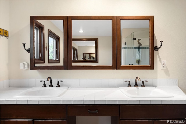 full bath featuring a shower stall and double vanity