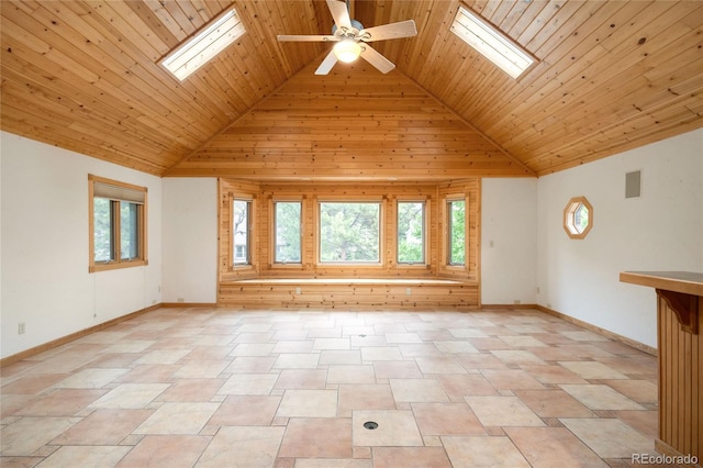 unfurnished room featuring a skylight, wooden ceiling, high vaulted ceiling, ceiling fan, and baseboards