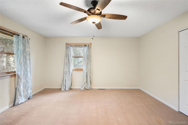unfurnished bedroom featuring carpet, a textured ceiling, baseboards, and ceiling fan
