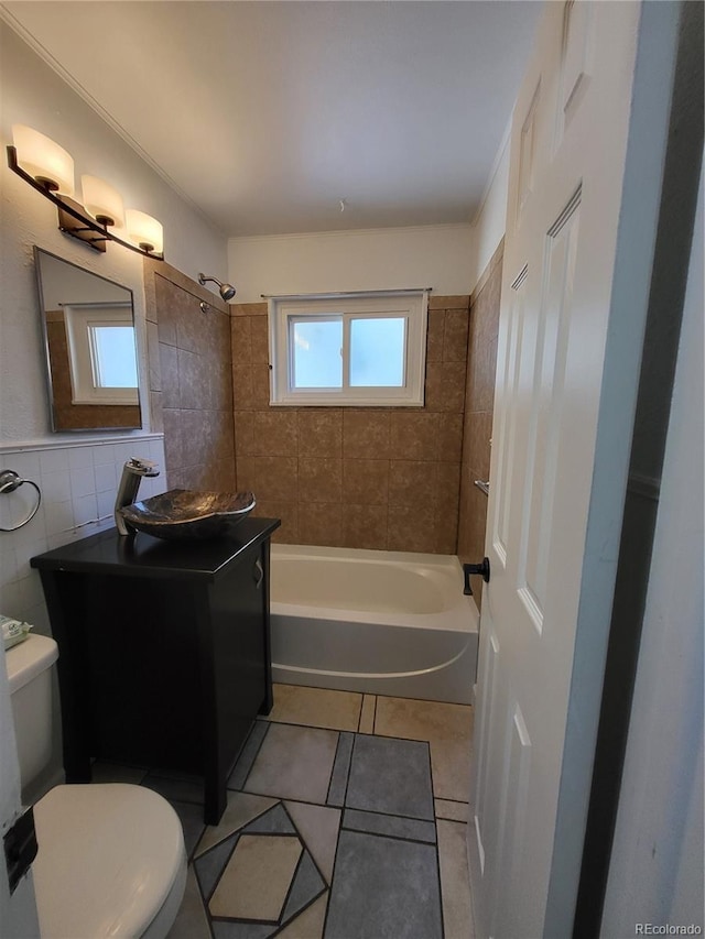 full bathroom featuring toilet, tiled shower / bath combo, tile walls, and tile patterned floors