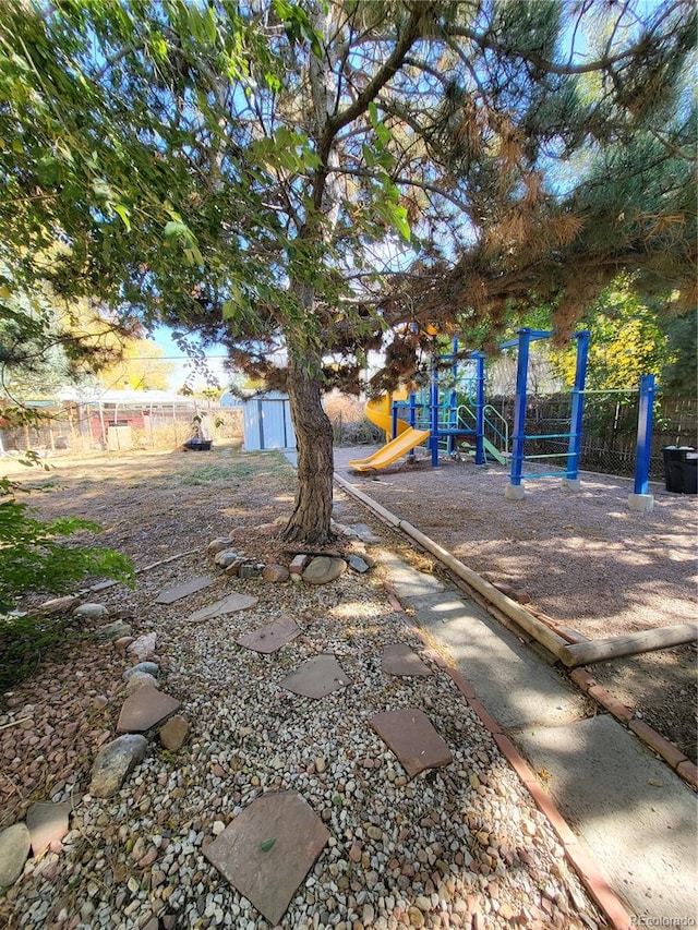 view of yard featuring a storage shed and a playground