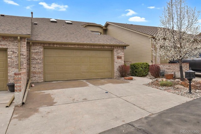 2866 Tenderfoot Hill St, Colorado Springs, CO 80906 - exterior space featuring an attached garage, a shingled roof, driveway, and brick siding