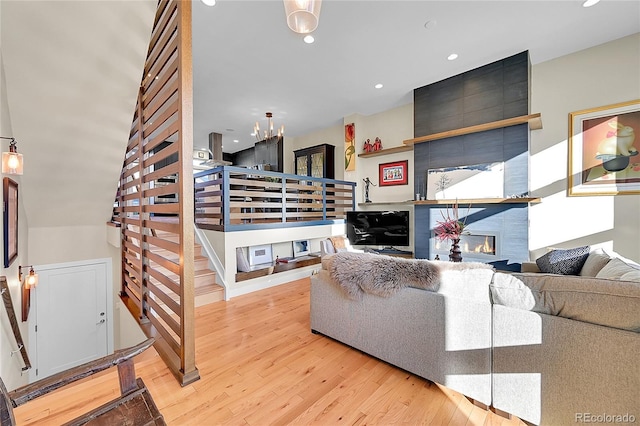 living room featuring a tiled fireplace and light hardwood / wood-style flooring