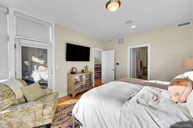 bedroom featuring ensuite bath and light hardwood / wood-style flooring