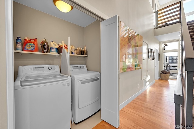 laundry area with washer and dryer and light wood-type flooring