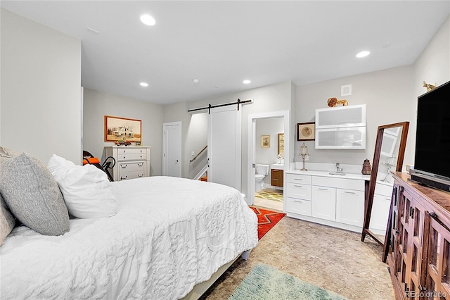 bedroom with sink, a barn door, and ensuite bathroom