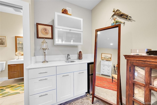 bar with fridge, sink, and white cabinets