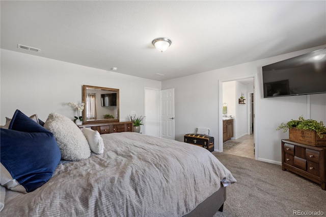 bedroom featuring light colored carpet and connected bathroom