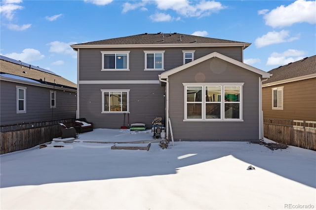 view of snow covered rear of property