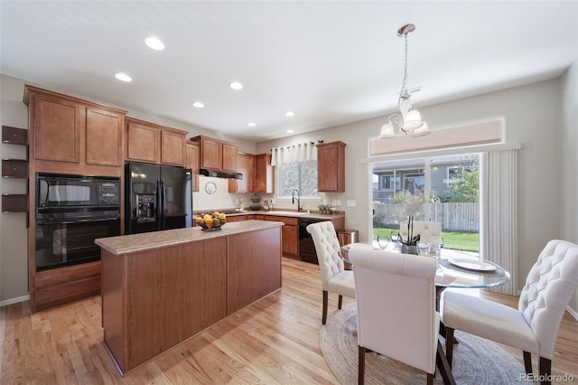 kitchen with a center island, light countertops, recessed lighting, light wood-style flooring, and black appliances