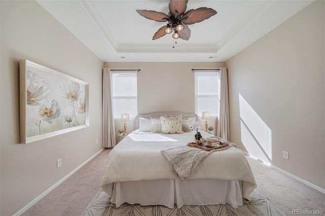bedroom with light colored carpet, multiple windows, and a raised ceiling