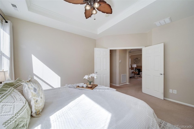 carpeted bedroom with a raised ceiling, baseboards, and visible vents