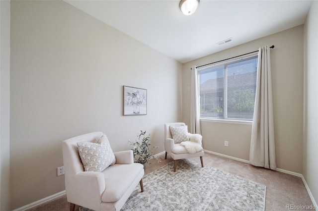 living area featuring visible vents, carpet, and baseboards